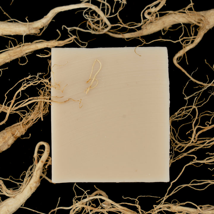 Triple Ginseng Anti-Aging Natural Soap bar with herbs on wooden tray